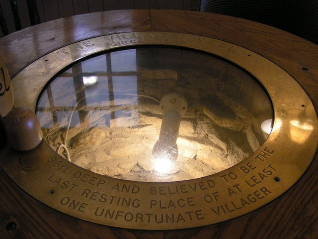 The real indoor well beneath a round glass-topped table at the Red Lion pub in Avebury, photographed in 2008; not a scene from The Conjuring: Unspoken