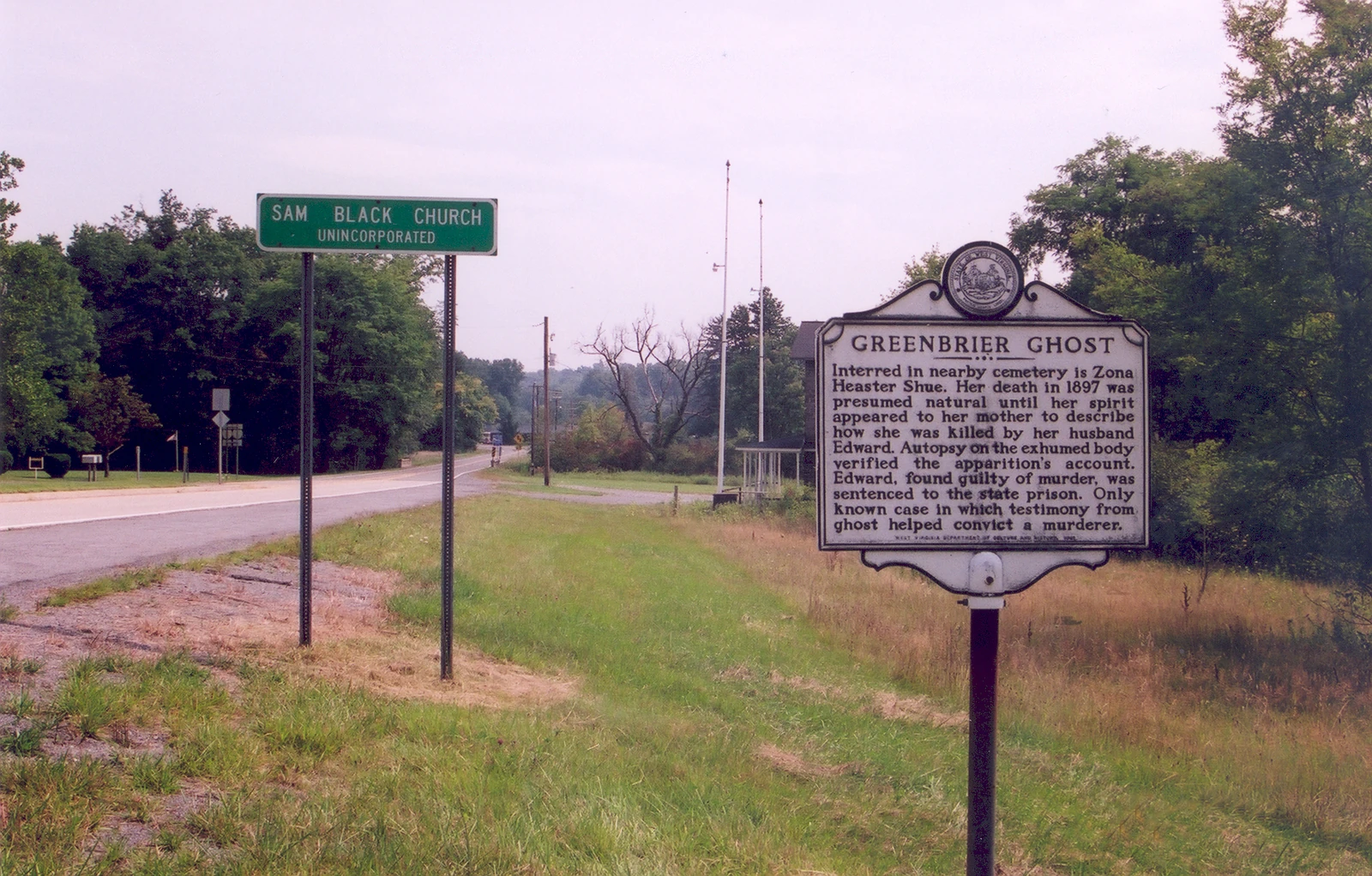 Roadside historical marker for the Greenbrier Ghost near Sam Black Church, West Virginia, photographed by A. E. Crane, with a separate green Sam Black Church sign