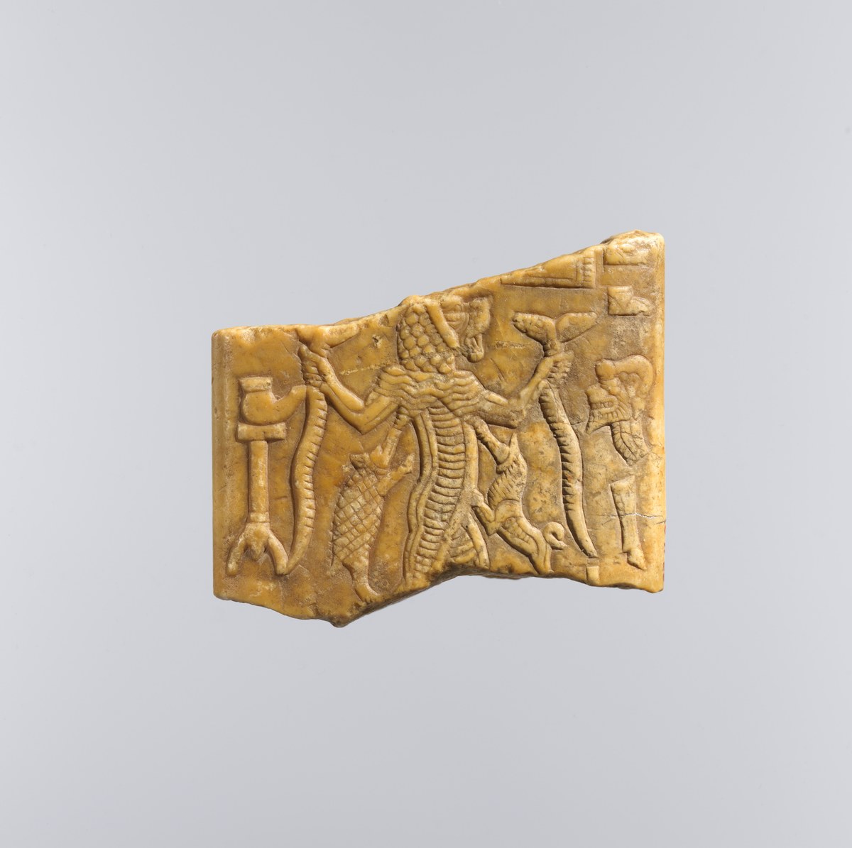 Terracotta plaque fragment showing Lamashtu striding between animals, with cuneiform inscriptions bordering the scene, 7th-6th century BCE