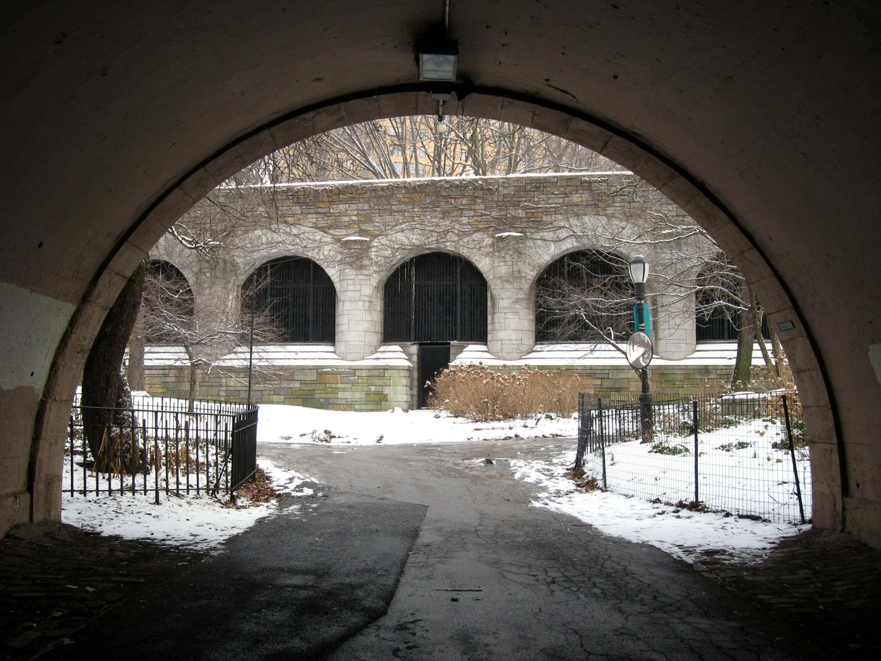 A stone railway arch frames a view of the gated West Side Line maintenance access in snowy Riverside Park, photographed in January 2009