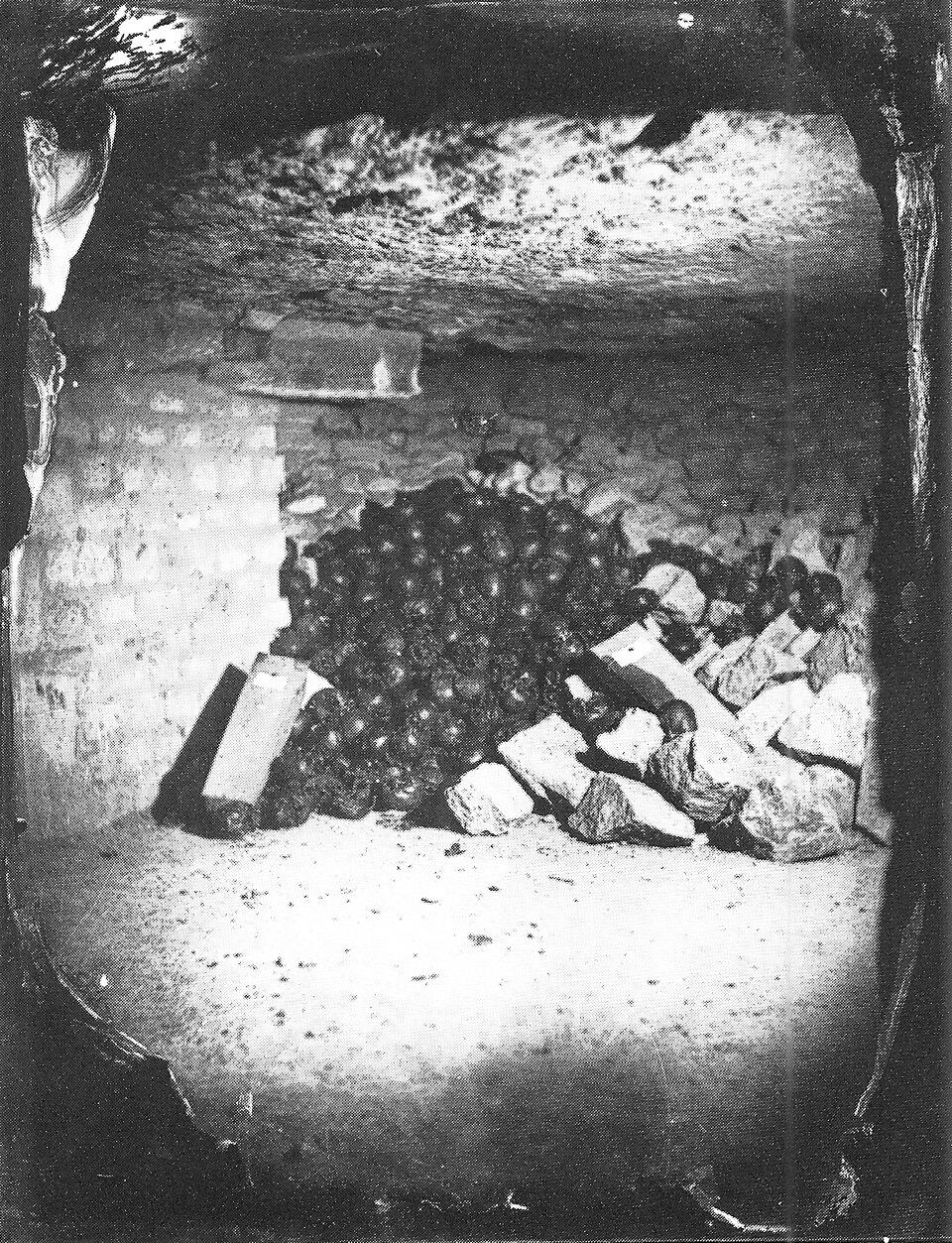Felix Nadar's 1861 photograph of the Paris Catacombs, showing a pile of skulls and a worker figure lit by early artificial light