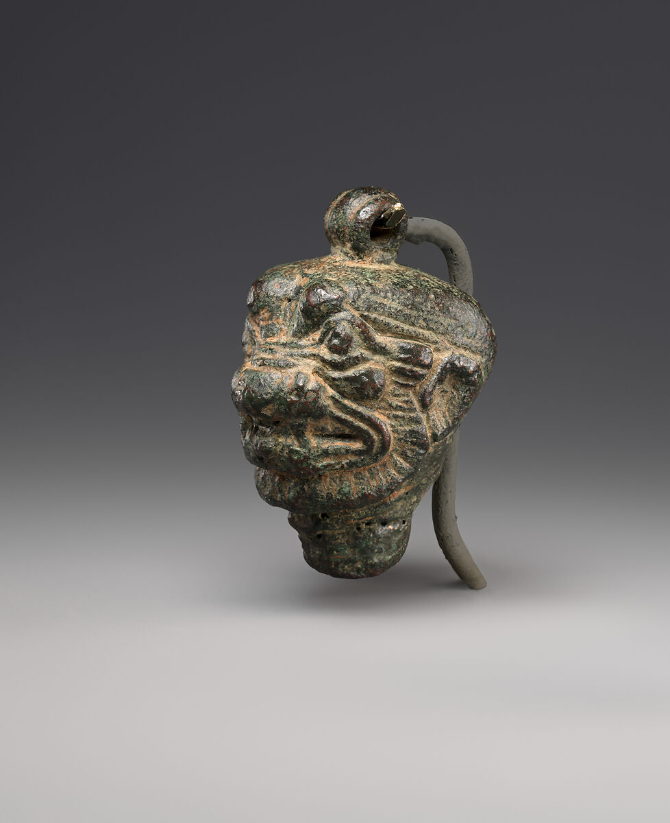 Side view of a Neo-Assyrian bronze pendant showing the head of Pazuzu