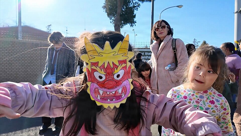 A child wearing a homemade paper oni mask with horns at a Setsubun bean-throwing event