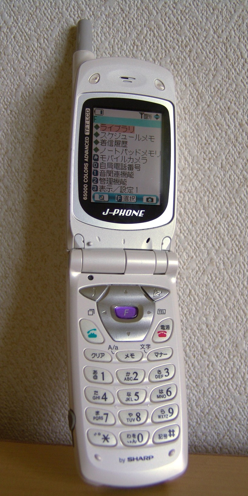 A Sharp J-SH07 Japanese mobile phone from 2001; real-world technology context for Signal Veil’s fictional supernatural phone